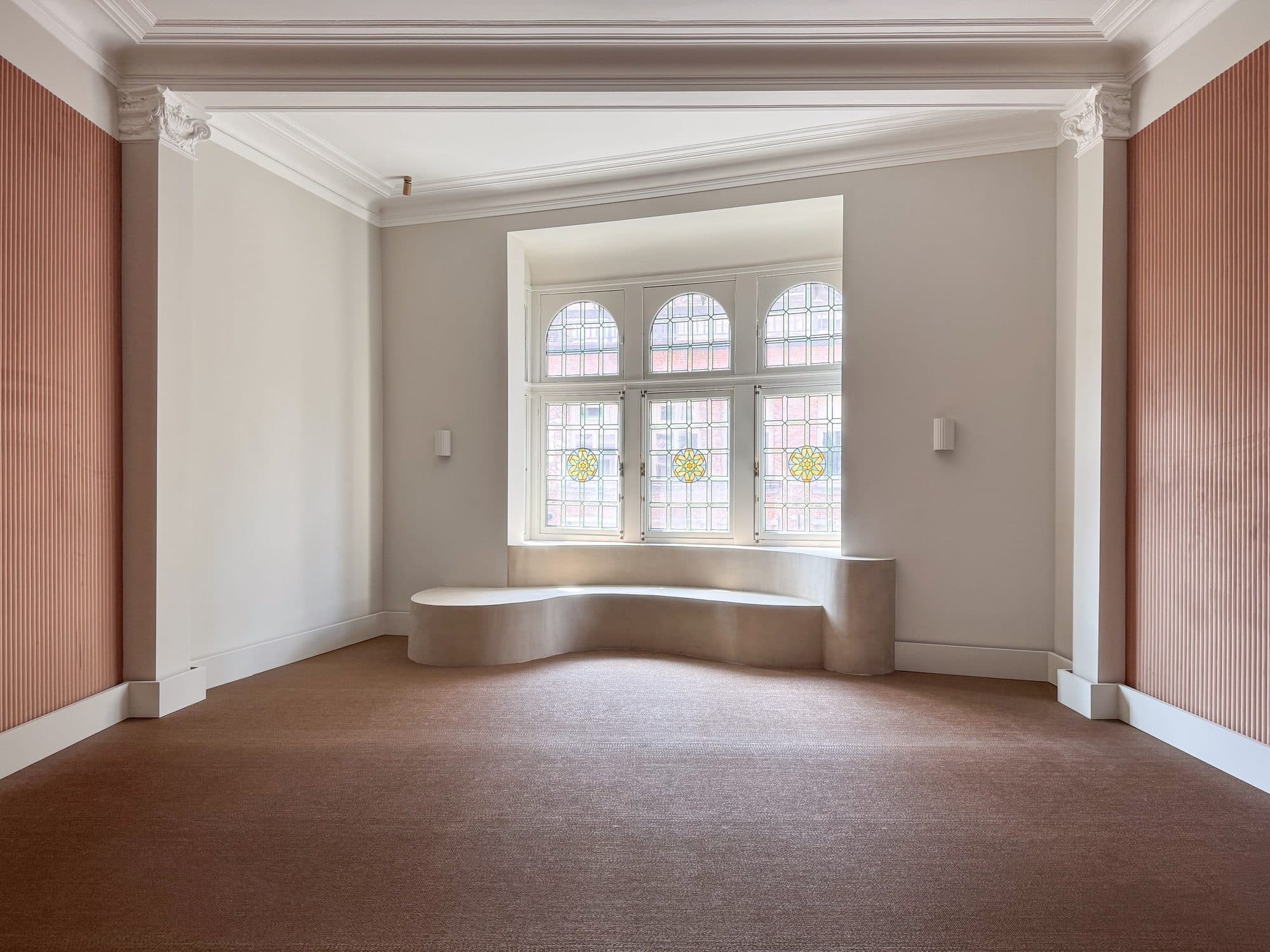 De zaal met loodglasnis en terracotta panelen